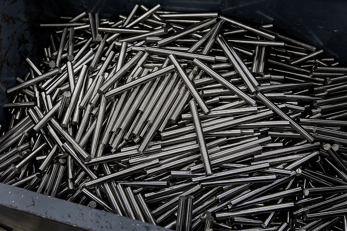 Swiss machines run from long bar stock — often 3–4 meters — fed through a bushing. This enables hours of unattended operation and very low per-part cost at high volume.
